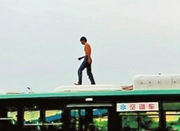 男子赤裸上身从天桥跳到公交车顶 举止怪异