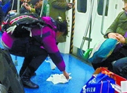 北京地铁乘客晕车呕吐 市民俯身擦净呕吐物
